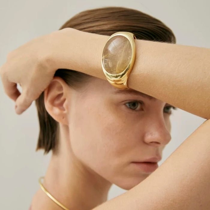 Vetgedrukte minimalistisch goud rutileerde kwarts breedbarmant